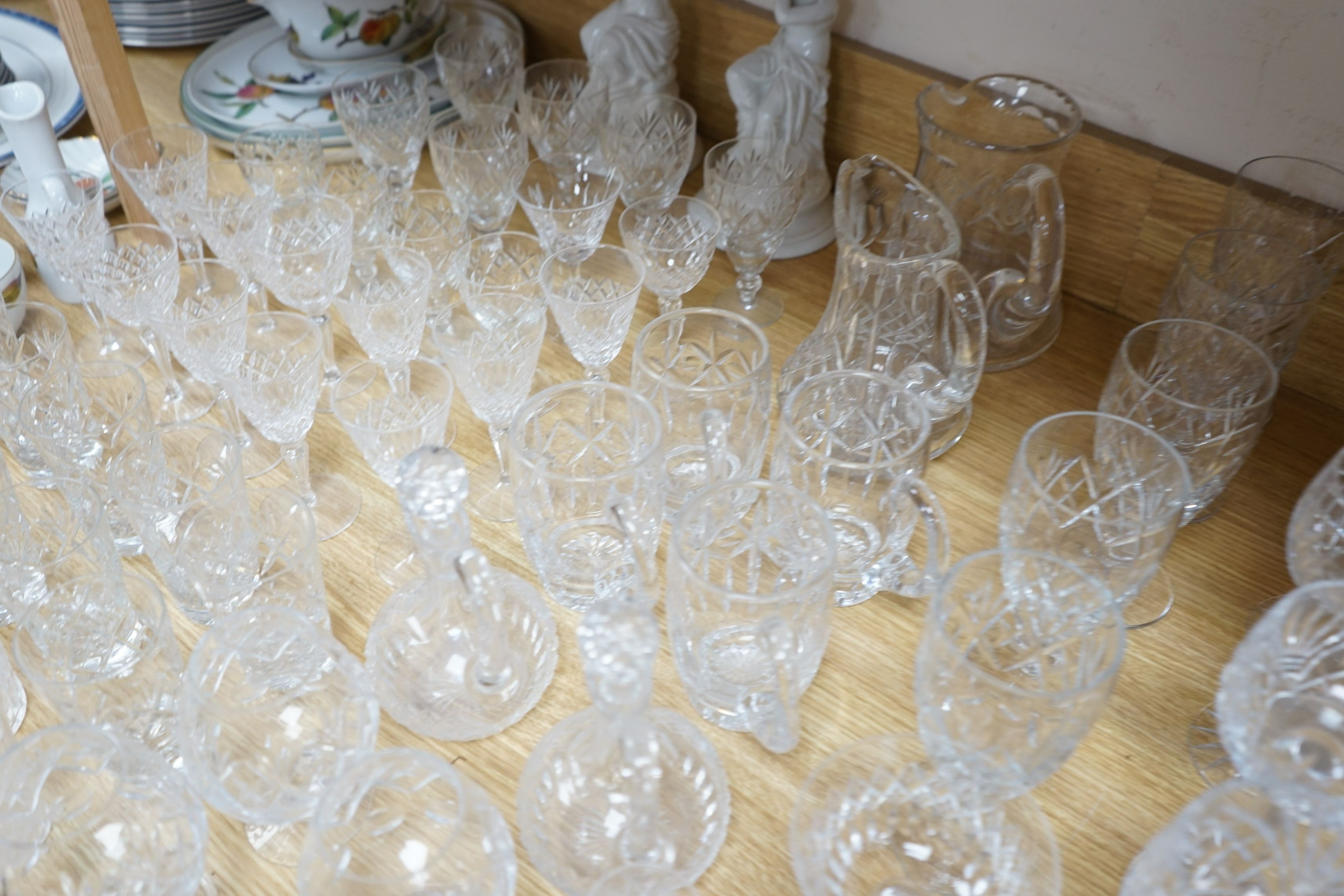 A suite of cut drinking glassware and a pair of porcelain figural lamp stems